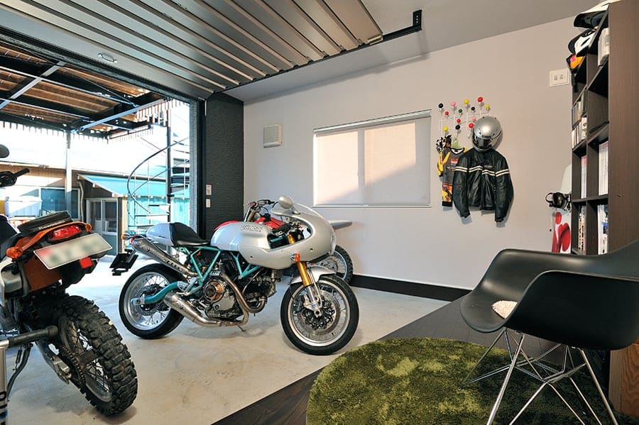バイク専用のインナーガレージとアウトドアリビングのある家の実例